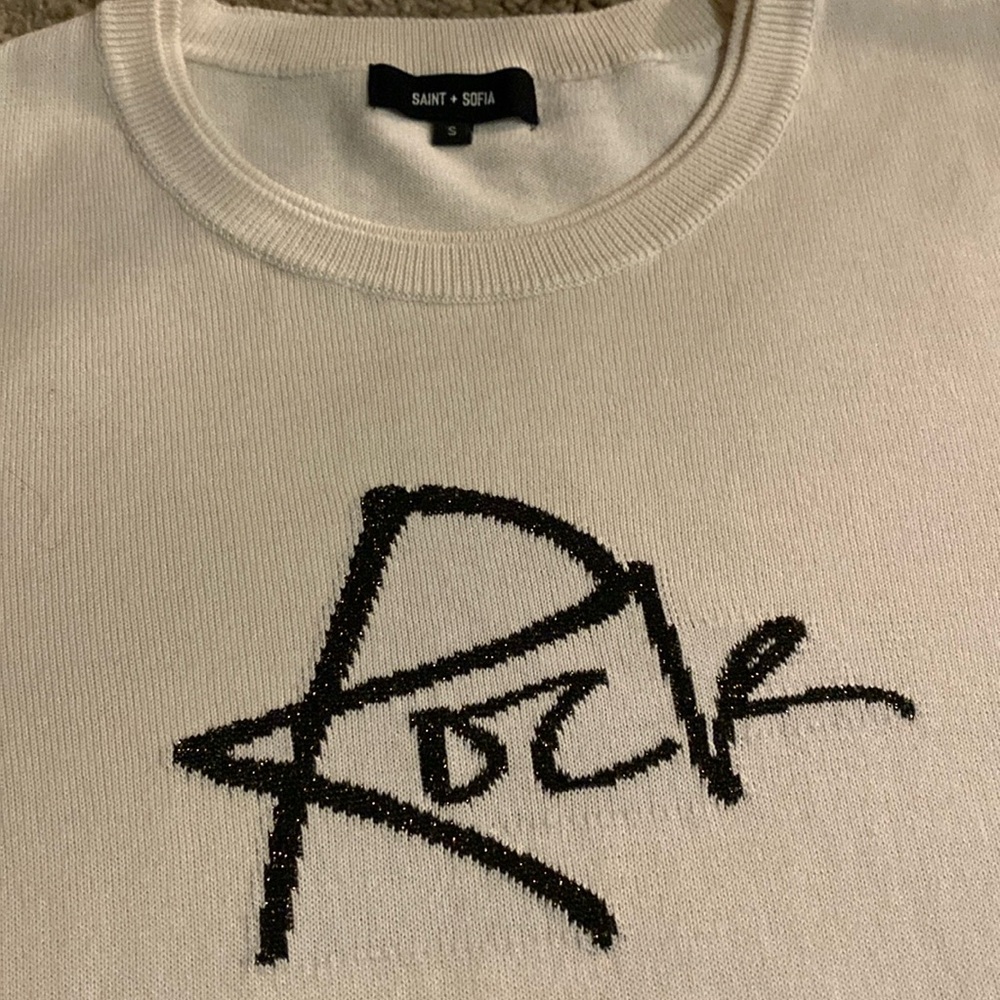 Sweater has ROCK in black with gold metallic threading on sleeve and band